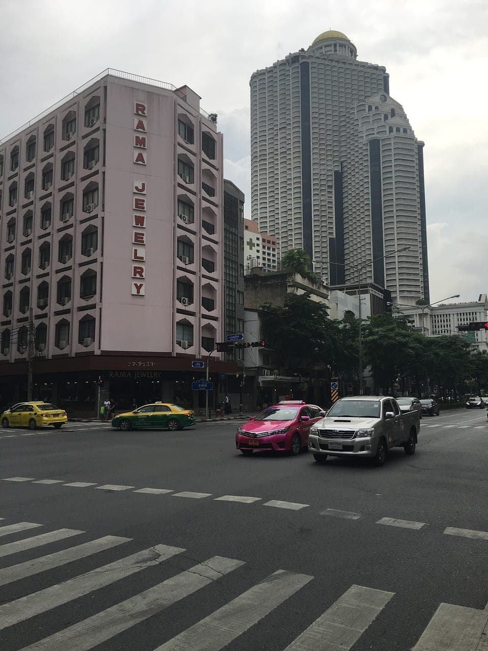 Silom Road corner with the Rama Jewelry building and the State Tower behind — the Bangkok gem-trade street