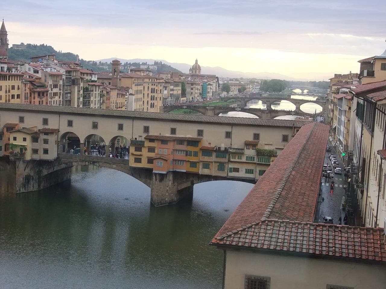 The Vasari Corridor running along the top of the bridge's shops, viewed from the river showing the elevated covered passage above the shopfronts