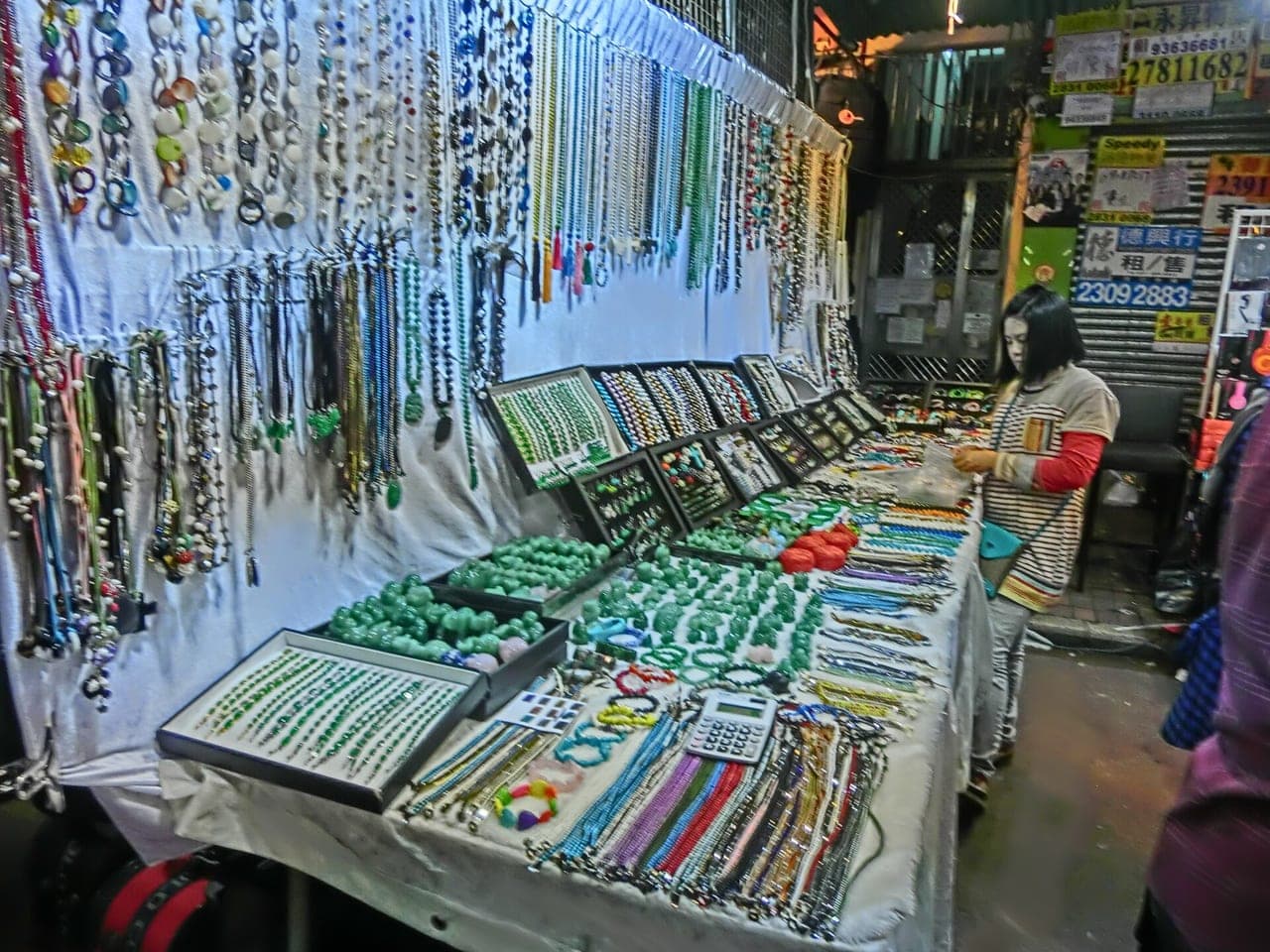 Jade wares displayed on a stall inside the Jade Market — bangles, pendants and carvings on a vendor's table