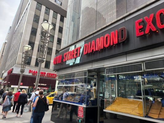 47th Street Diamond Exchange storefront with red neon signage and busy sidewalk scene